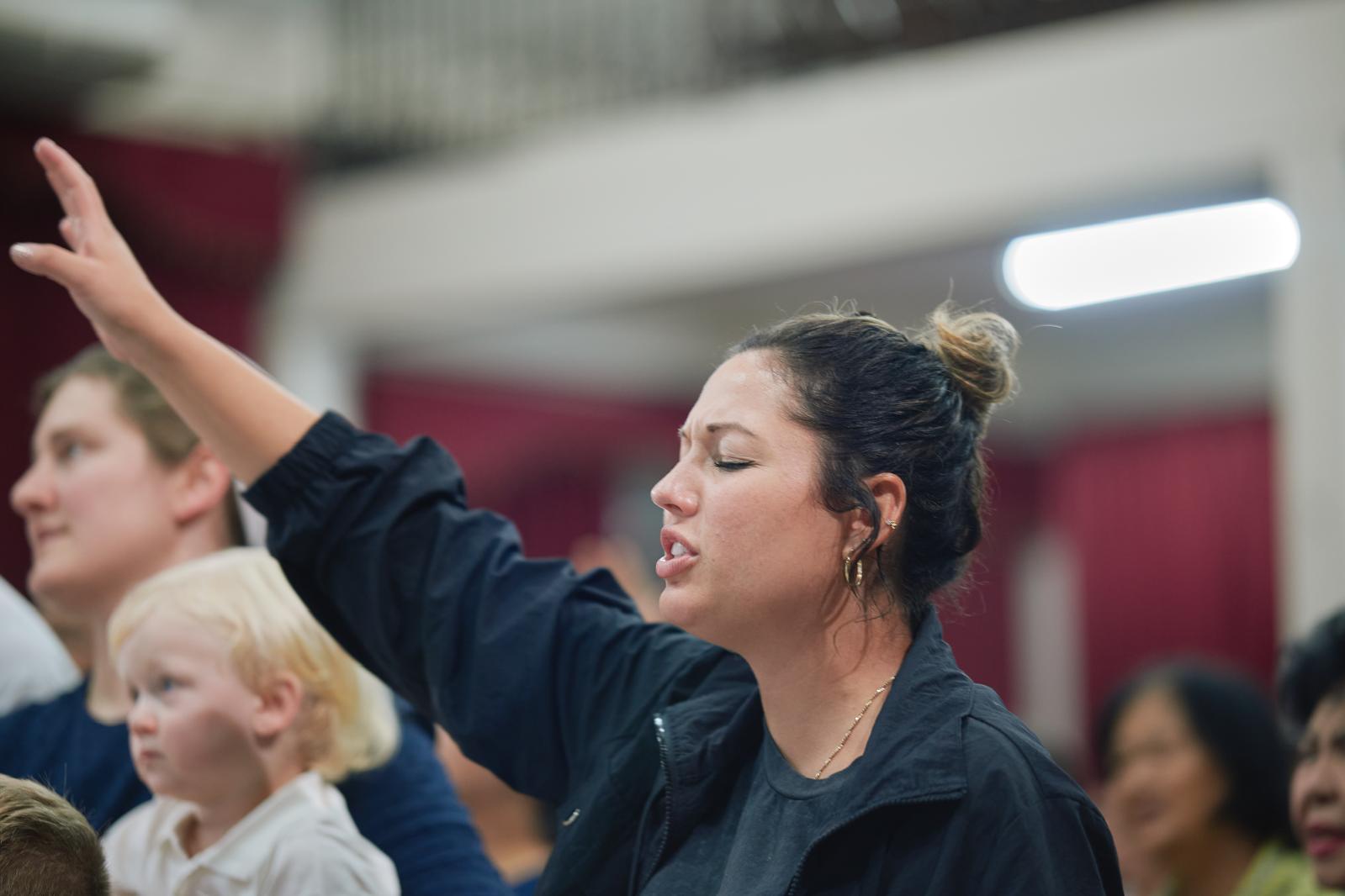 Kimmie Liette worshipping with her eyes closed and one hand raised